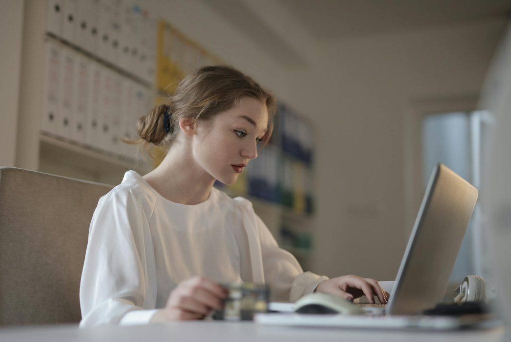 Focused woman working on a laptop in an office setting, representing professional financial services at Daybook Financial Group.