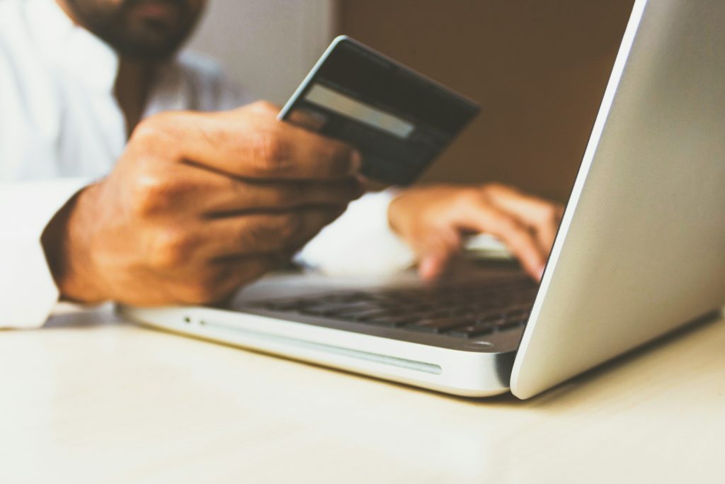 Credit card transaction on laptop for financial services, online banking, or digital payments.