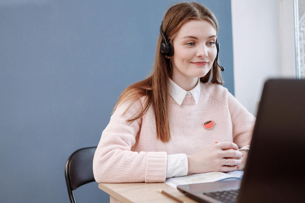Friendly customer service representative with a headset working at a computer, providing financial advice and support for clients at Daybook Financial Group.